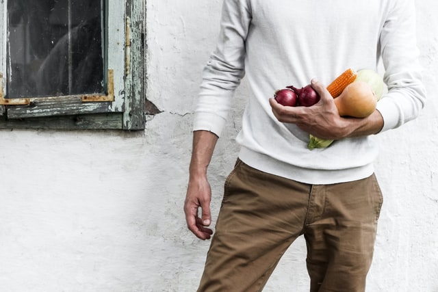 man holding vegetables with fruit